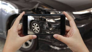 Woman documenting evidence, taking pictures of the car accident